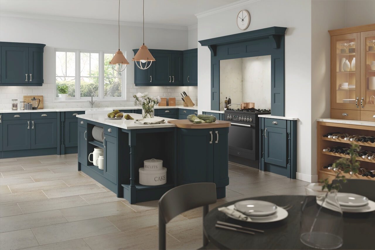 Navy island kitchen with copper pendants