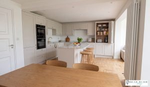 ultra realistic render shaker timber mussel kitchen with porcelain laminam worktops and bifold breakfast unit