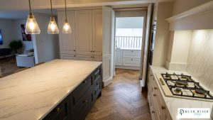beau bijou design ultra realistic render. mussel traditional moulded shaker kitchen and graphite island with quartz worktops and timber floor